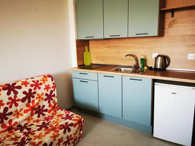 a kitchen with a chair and a sink at Privately owned Studios Bora Bora in Nesebar