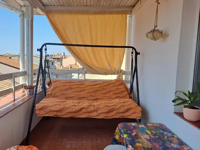 a bed on a balcony with a window at Панорама in Pomorie