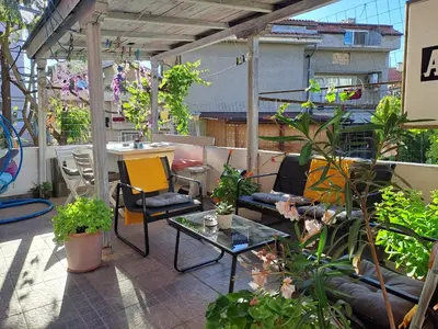 a patio with a table and chairs and plants at Панорама in Pomorie