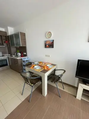 a kitchen with a table and chairs in a kitchen at Flat on the beach in Chernomorets