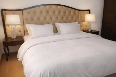 a large white bed with two lamps on two tables at Luxury Studio in Sunny Beach with Pool, 5 Mins Walk to Beach in Sunny Beach
