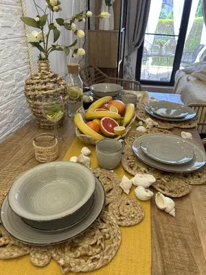 a table with plates and fruit on top of it at Green Life Boho Apartment in Sozopol