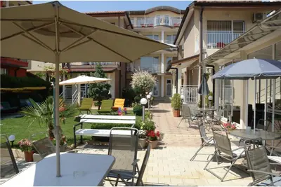 a patio with tables and chairs and an umbrella at Family house ''Siema'' in Nesebar