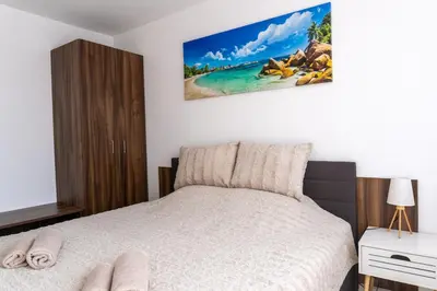 a bedroom with a bed and a picture of a beach at Soleil Bleu Beachfront Getaway in Nesebar