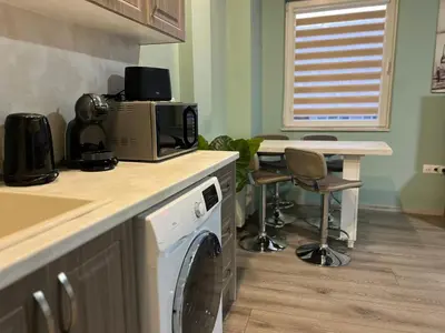 a kitchen with a washing machine and a counter with a sink at Varna Central Seaside Suite in Varna City