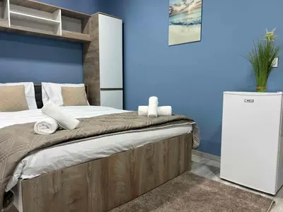 a bedroom with a large bed and a blue wall at Varna Central Seaside Suite in Varna City