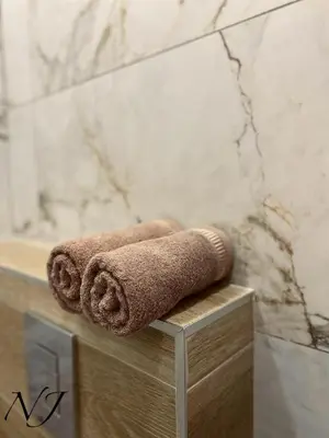 a couple of towels sitting on a counter in a bathroom at NJ Collection in Varna City