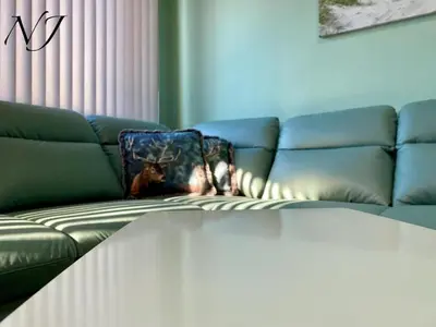 a living room with a couch with a blanket on it at NJ Collection in Varna City