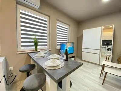 a kitchen with a table and two stools in a room at NJ Collection in Varna City