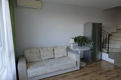 a living room with a couch and a table at Large Two Floor Apartment in Byala
