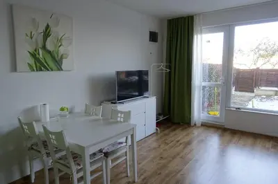 a living room with a white table and a television at Large Two Floor Apartment in Byala