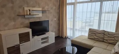 a living room with a flat screen tv and a couch at East Beach Marina View Apartment in Sveti Vlas