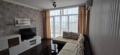 a living room with a couch and a television at East Beach Marina View Apartment in Sveti Vlas
