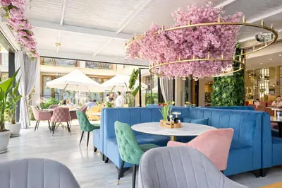 a restaurant with blue chairs and tables and flowers at Harmony Suites-2 Private Apartment 404 in Sunny Beach