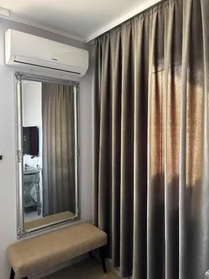 a mirror and a chair in front of a window at Golden Nest B25 in Nesebar