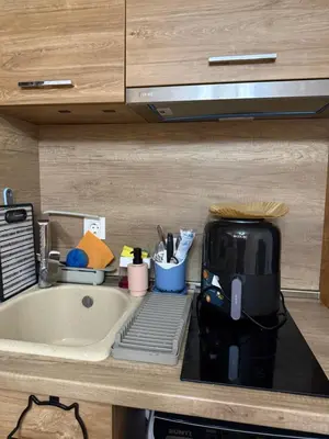a kitchen counter with a coffee maker next to a sink at Студио-Джени in Burgas City