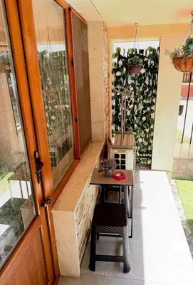 a small porch with a table and a door at Студио-Джени in Burgas City