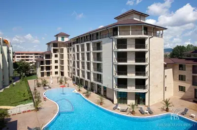 a large building with a swimming pool next to a resort at Amadues Lux, 1 Bed - Central to Sunny Beach in Sunny Beach