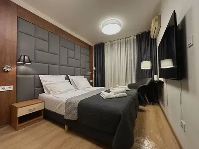 a bedroom with a large bed and a television at Слънчев Бряг Какао с басейн плаж in Sunny Beach