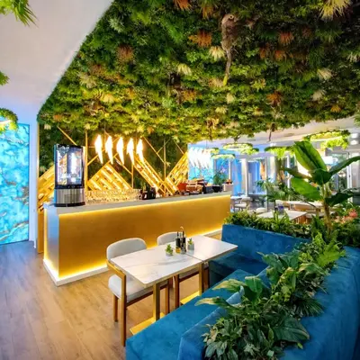 a restaurant with a ceiling covered in plants at Harmony Suites Grand Resort-15 Private Apartment in Sunny Beach