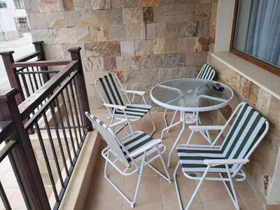 a patio with chairs and a table on a balcony at Apartment in Byala Vista Compex in Byala