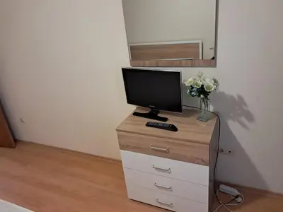 a television on a dresser with a vase of flowers at Apartment in Byala Vista Compex in Byala