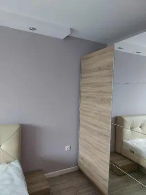 a bedroom with a bed and a mirror at Izgrev View apartment bs in Burgas City