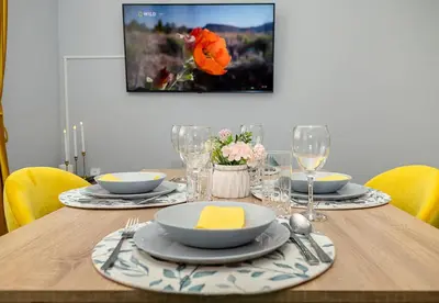 a wooden table with plates and bowls on top of it at Stylish 2BR Apartment with Underground Parking, Varna by Flat Manаger in Varna City