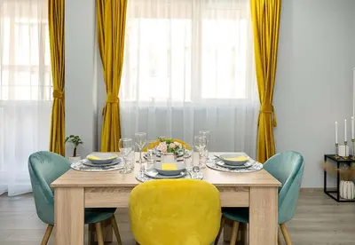 a dining room table with a yellow chair and a yellow chair at Stylish 2BR Apartment with Underground Parking, Varna by Flat Manаger in Varna City
