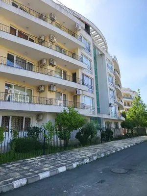 an apartment building with a fence next to a street at Luxury apartment opposite Kakao in Sunny Beach