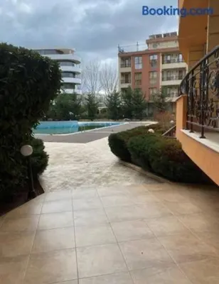 a walkway in a city with a pool and buildings at Marvel Deluxe in Sunny Beach