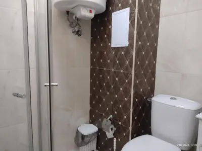 a small bathroom with a toilet and a shower at Marvel Deluxe in Sunny Beach