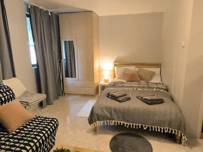 a bedroom with a large bed and a chair at Top Center Apartment in Varna City
