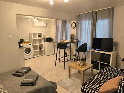 a bedroom with a bed and a kitchen with a table at Top Center Apartment in Varna City