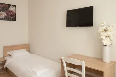 a bedroom with a bed and a table with a television at Леглото in Topoli