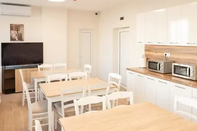 a kitchen with tables and chairs and a microwave at Леглото in Topoli
