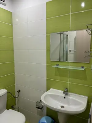 a bathroom with a sink and a toilet and a mirror at Beachside apartment - 100 meters from the sea in Chernomorets