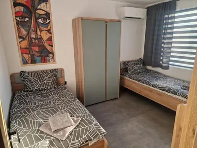 a small room with two beds and a window at Family House Burgas in Burgas City