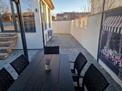 a wooden table and chairs on a patio at Family House Burgas in Burgas City