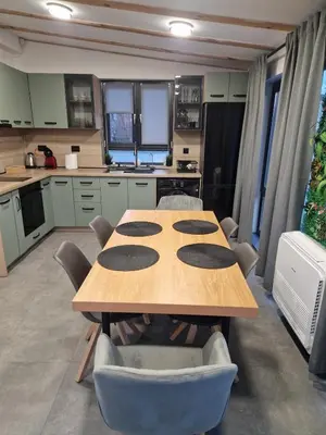 a large kitchen with a wooden table and chairs at Family House Burgas in Burgas City