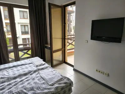 a bedroom with a bed and a flat screen tv at Sunny sea apartment - 100 meters from the sea in Chernomorets