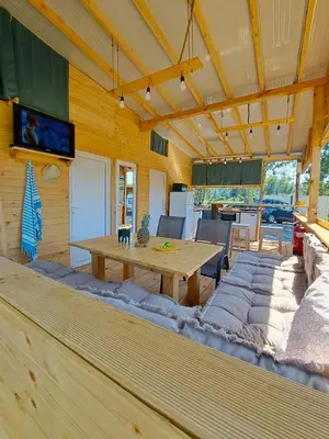 a living room with a wooden table and a couch at Бунгало Лимонада in Chernomorets