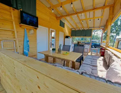 a wooden cabin with a table and a tv on the wall at Бунгало Лимонада in Chernomorets