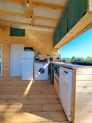 a kitchen with a washer and dryer in a cabin at Бунгало Лимонада in Chernomorets