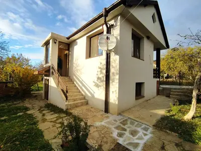 a house with a clock on the side of it at При Приятели in Nesebar