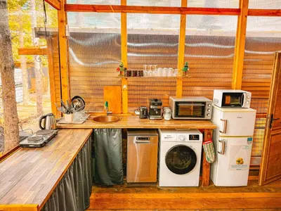 a kitchen with a washing machine and a microwave at Бунгало Борче in Burgas City