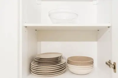 a stack of plates in a white cabinet at Seaside Bliss in Varna City