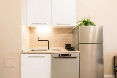 a kitchen with white cabinets and a stainless steel refrigerator at Seaside Bliss in Varna City