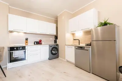 a kitchen with white cabinets and a stainless steel refrigerator at Seaside Bliss in Varna City