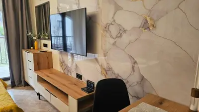 a living room with a tv on a wall at Vladan apartments in Sozopol